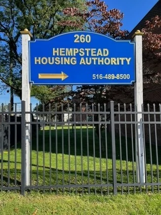Hempstead Housing Authority sign with directional arrow and phone number.