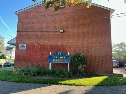 General Douglas Mac Arthur Senior Village sign at the entrance of a brick building.