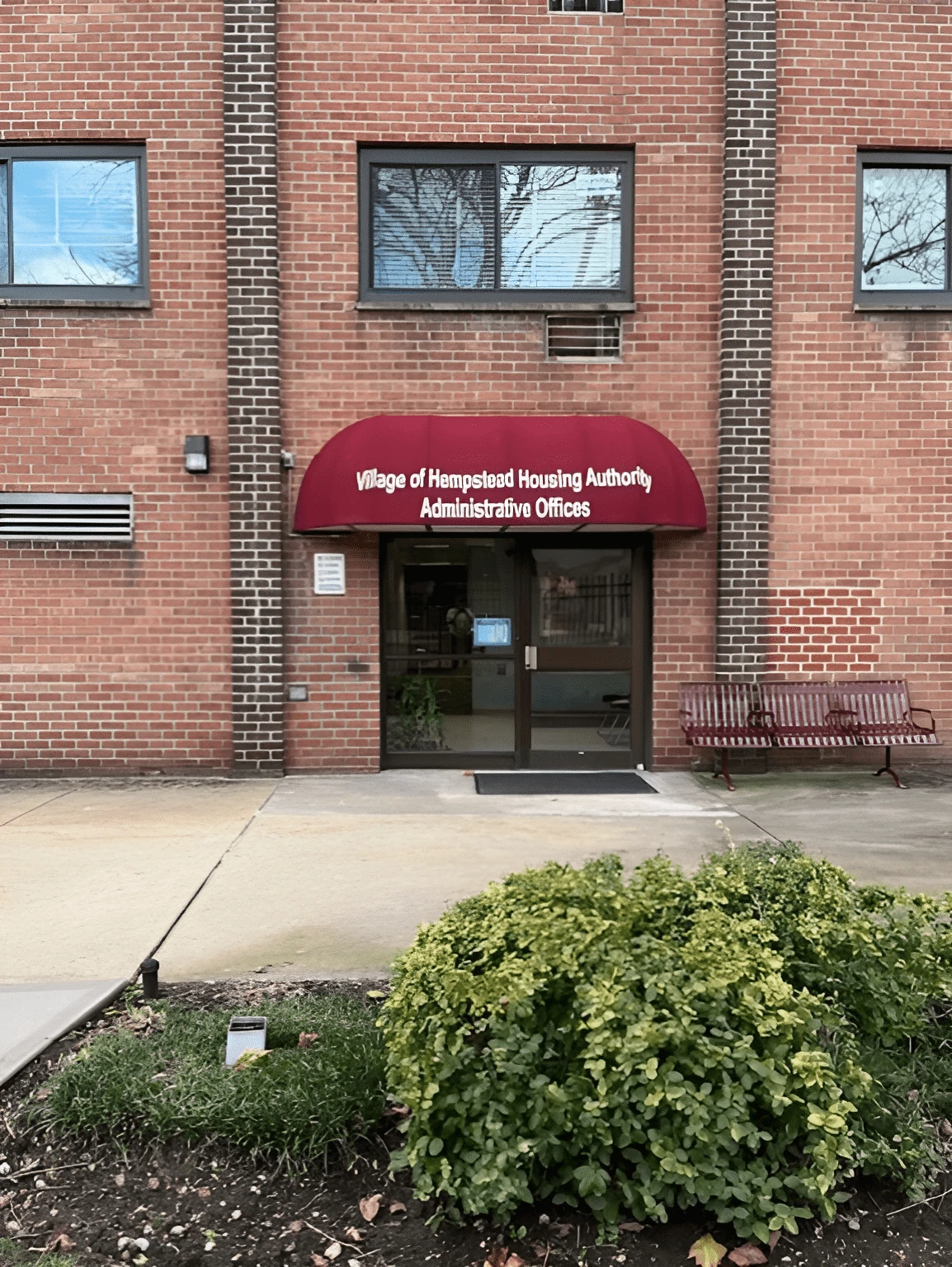 Village of Hempstead Housing Authority building entrance with a red awning.